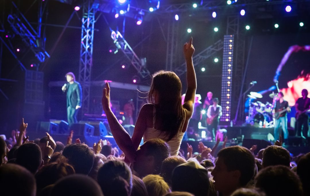 Un chica a hombros en un concierto organizado por los mejores organizadores de eventos para ayuntamientos